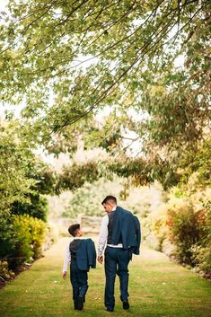 a father and son walking down a path holding hands