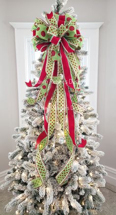 a decorated christmas tree with red and green bows