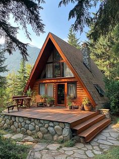 a wooden cabin with steps leading up to the front door and covered porch in the woods