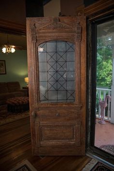 an old wooden door with glass in front of a patio and outside area that is lit by the sun