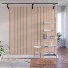 a living room with pink striped wallpaper and wooden flooring next to a book shelf