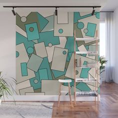 a wall mural with blue and green geometric shapes on it's side, along with a ladder in the foreground