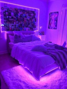 a bed with purple lights in a bedroom next to a window and pictures on the wall