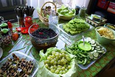 a table filled with lots of food on top of a green cloth covered tablecloth