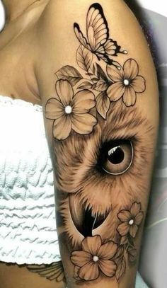 an owl and flowers tattoo on the arm