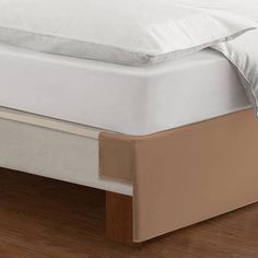 a bed with two pillows on top of it and a pillow under the mattress cover