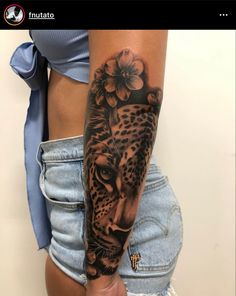 a woman's arm with a leopard and flowers tattoo on the left side of her body