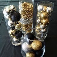 several glass vases with ornaments in them on a black table cloth covered tablecloth