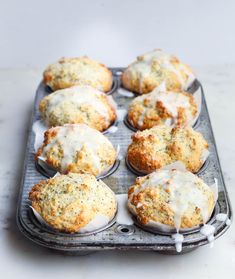 muffins with white icing sitting on a baking tray