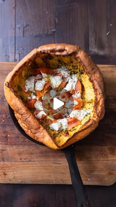 a pizza sitting on top of a wooden cutting board