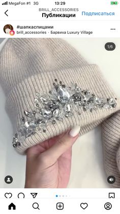 someone is holding up a beanie with jewels on it