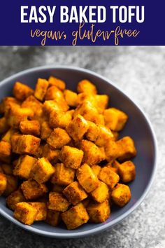 a blue bowl filled with cubed tofu on top of a gray countertop