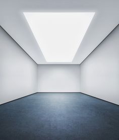 an empty room with a skylight in the center and blue carpet on the floor