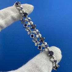 * Designer 925 Sterling Silver Blue Sapphire Diamond X O Statement Tennis Bracelet * Length: 7-1/2" * Width: 3/8" * Blue Sapphire total carat weight: approximately 8.80 tcw * Diamond total carat weight: approximately .02 tcw * Bracelet weight: 12.9 tgw * Marked: MAKERS MARK * 925 * CHINA * Condition: As pictured. * S4430    Exported By ExportYourStore :) Classic Blue Diamond Bracelet In Sterling Silver, Classic Blue Sterling Silver Diamond Bracelet, Classic Blue Sterling Silver Tennis Bracelet, Blue Sterling Silver Diamond Bracelet, Blue Diamond Sterling Silver Bracelet, Blue Sterling Silver Diamond Jubilee Bracelet, Blue Gemstone Diamond Bracelet In Sterling Silver, Blue Sterling Silver Tennis Bracelet For Anniversary, Bracelet Tennis