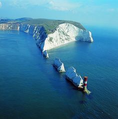 an aerial view of the white cliffs and lighthouses in the ocean near landforms