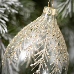 a silver ornament hanging from a christmas tree