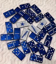 blue and silver dominos laying on top of a white blanket with the word cowboys written on them