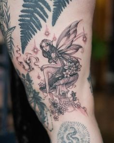 a woman's leg with a fairy tattoo on it