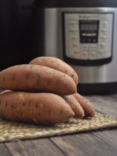 three sweet potatoes stacked on top of each other in front of an instant pot