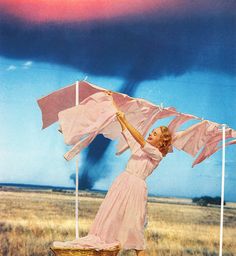 a woman in a pink dress is holding an umbrella over her head while standing on a field