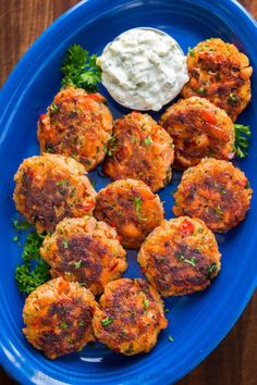 salmon patties on a blue plate with sour cream