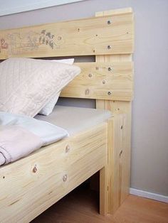 a bed with two pillows on top of it next to a wooden headboard and foot board