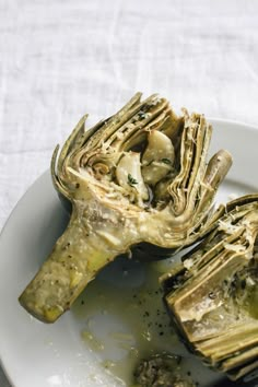 an artichoke is sitting on a white plate