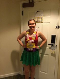 a woman standing in front of a door with her hands on her hips wearing a green skirt