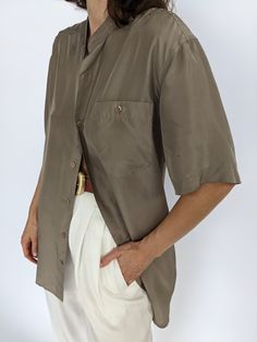 Beautiful latte toned silk top - this blouse has a collarless neckline and iridescent matching buttons down the front & a single breast pocket. Tag reads Personal Choice Faint discolorations at the sleeves and at front with very subtle discolorations under arms. Classic Daywear Blouse With Buttoned Pockets, Formal Collared Top With Buttoned Pockets, Formal Button-up Top With Pockets, Vintage Silk Blouse, Classic Silk Blouse With Short Sleeves, Elegant Solid Color Blouse With Pockets, Elegant Summer Shirt With Pockets, Chic Formal Blouse With Pockets, Formal Button-up Blouse With Pockets