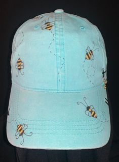 a light blue hat with bees on it