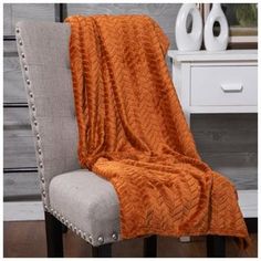 an orange blanket sitting on top of a chair