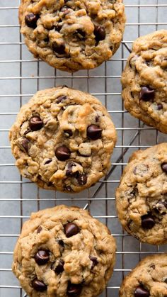 chocolate chip cookies cooling on a wire rack with one cookie in the middle and four out