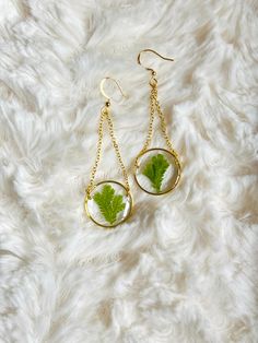 Hand picked and dried fern/moss from my own garden! These lovely earrings showcase a round frame preserving a piece of fern/moss in resin. Choice of huggies or fishhooks. Metal is either gold plated or silver plated.  ❌DisclaimerAll flowers are different from one another. That's nature. I do my best to pair up flowers of similar color and shape for each pair of earrings. Some pieces may tarnish with time. That's why a jewelry cloth is included with every purchase. I do my best to make the resin as clear as possible. With that being said, you are likely to spot some air bubbles within each piece. It just makes each piece that much more unique! Unless otherwise stated in the listing, there's no guarantee you will get the exact item pictured. Again, all flowers are different. I do my best to Green Pressed Flower Drop Earrings, Botanical Green Jewelry With Ear Wire, Dried Fern, Fern Moss, Fern Earrings, Silver Dangle Earrings, Huggie Earrings, Lovely Earrings, All Flowers