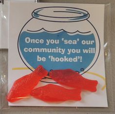 there are two red fish in the bag on the table next to it is a sign that says, once you sea our community you will be hooked