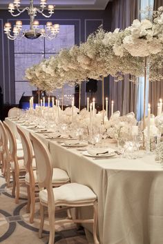 a long table is set with white flowers and candles for an elegant wedding reception at the four seasons hotel