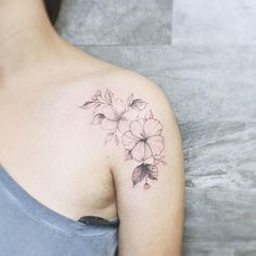 a woman with a flower tattoo on her shoulder