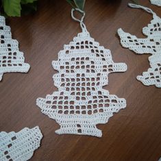 white crocheted ornaments hanging on a wooden table