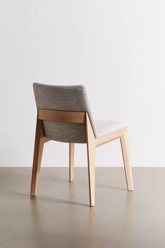 a chair sitting on top of a hard wood floor next to a white wall in an empty room