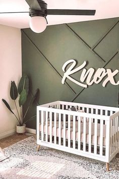 a white crib in front of a green wall with the word rox on it