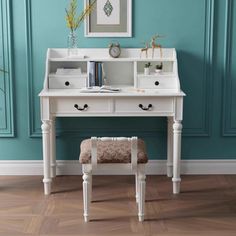 a white desk and chair in front of a blue wall