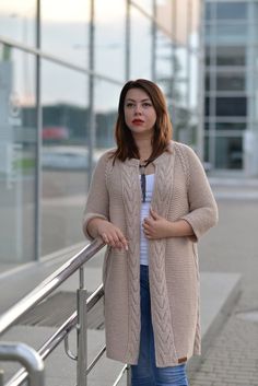 a woman leaning against a railing with her hand on her hip and looking at the camera