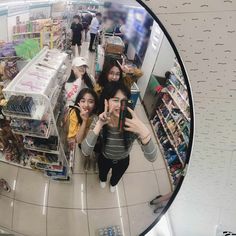 a group of people standing in front of a mirror