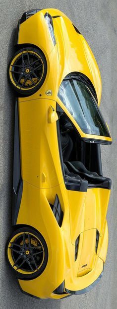 the top view of a yellow sports car from above, looking down on it's wheels