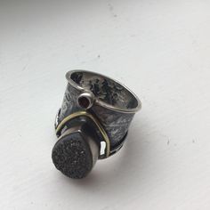 Artisan Crafted Grey Druzy, Sterling Silver And 14k Gold Ring Is Nwot! In Brand New Unworn Condition. Artisan Crafted So Didn’t Come With Tags. Sterling Silver Etched Cigar Band With Tear Drop Shaped Grey Druzy And 14k Gold Accents. Tiny Round Garnet Below The Druzy. It's So Hard To Highlight The Sparkle Of The Grey Druzy In These Photos; Didn't Help That It Was A Cloudy Old Day. Size 6: Just Under One Inch Wide At Its Widest Point; Band Is Thicker In Front Than The Back. Retailed For $136. Artisan One Of A Kind Open Ring Jewelry, Artisan One-of-a-kind Open Ring Jewelry, Hand Cast Sterling Silver Wide Band Jewelry, Artisan Wide Band Jewelry As Gift, Hand Cast Wide Band Jewelry Gift, Artisan Silver Teardrop Rings, Unique Oxidized Finish Jewelry For Anniversary, Unique Jewelry With Oxidized Finish For Anniversary, Unique Oxidized Jewelry For Anniversary