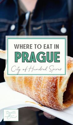 a person holding a pastry with the words where to eat in prague