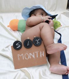 a baby laying on top of a bed wearing a hat