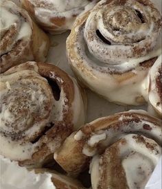 cinnamon rolls with icing sitting on top of each other