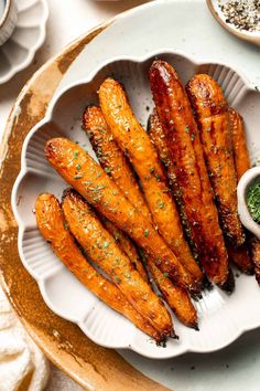 the plate is full of cooked carrots with herbs and seasoning on it, along with other dishes