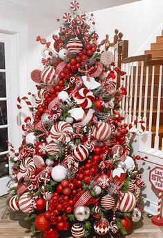 a christmas tree decorated with candy canes, ornaments and candies in red and white