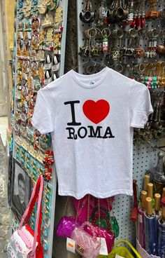 a t - shirt that says i love roma hanging on a rack in a store